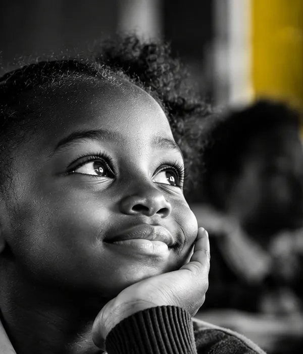 A smiling girl in school uniform resting her chin on her hand